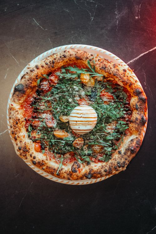 Free Delicious Italian pizza topped with fresh arugula, tomatoes and mozzarella cheese. Stock Photo