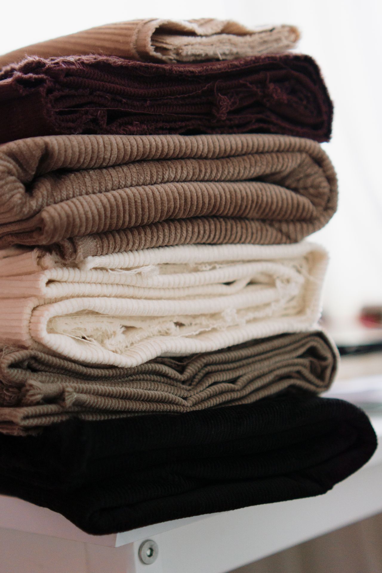 Stack of folded throws in neutral tones