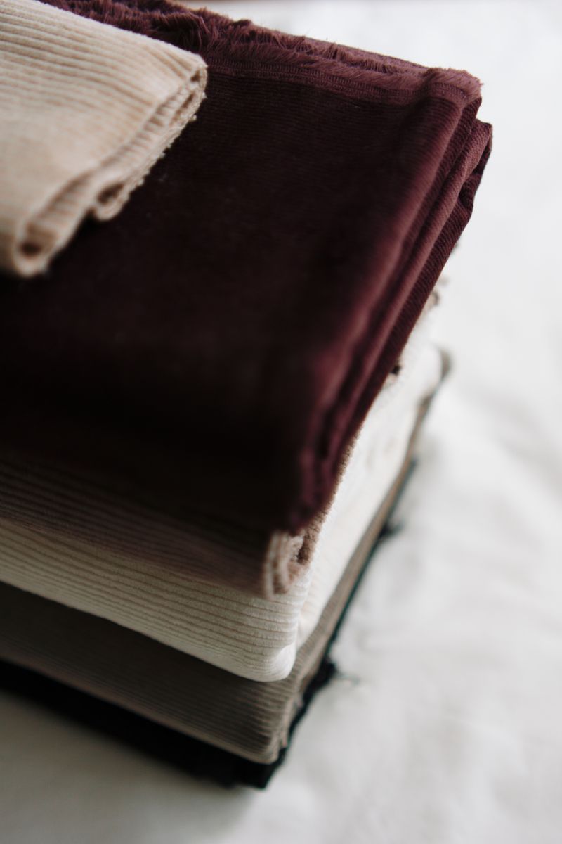 Folded velvet lengths in cream and oxblood — Berna on Pexels