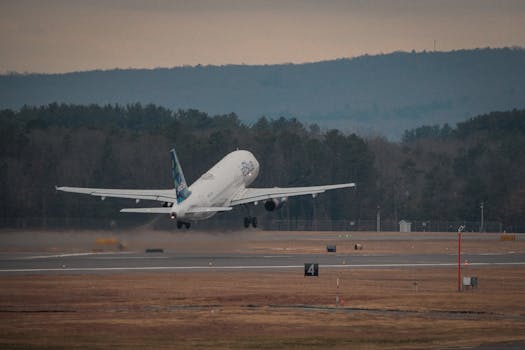 Airbus A320 taking off from a runway at Windsor Locks, Connecticut during twilight, showcasing air travel.