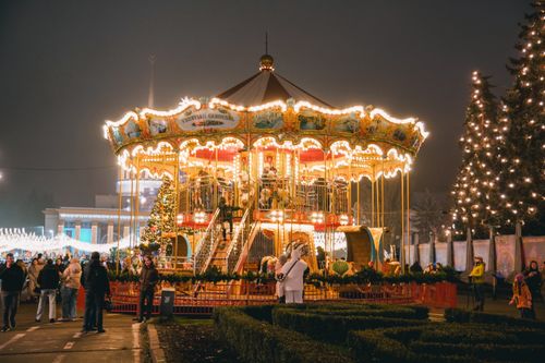 Free A vibrant Christmas carousel in Kyiv, Ukraine at night, surrounded by people enjoying the holiday spirit. Stock Photo