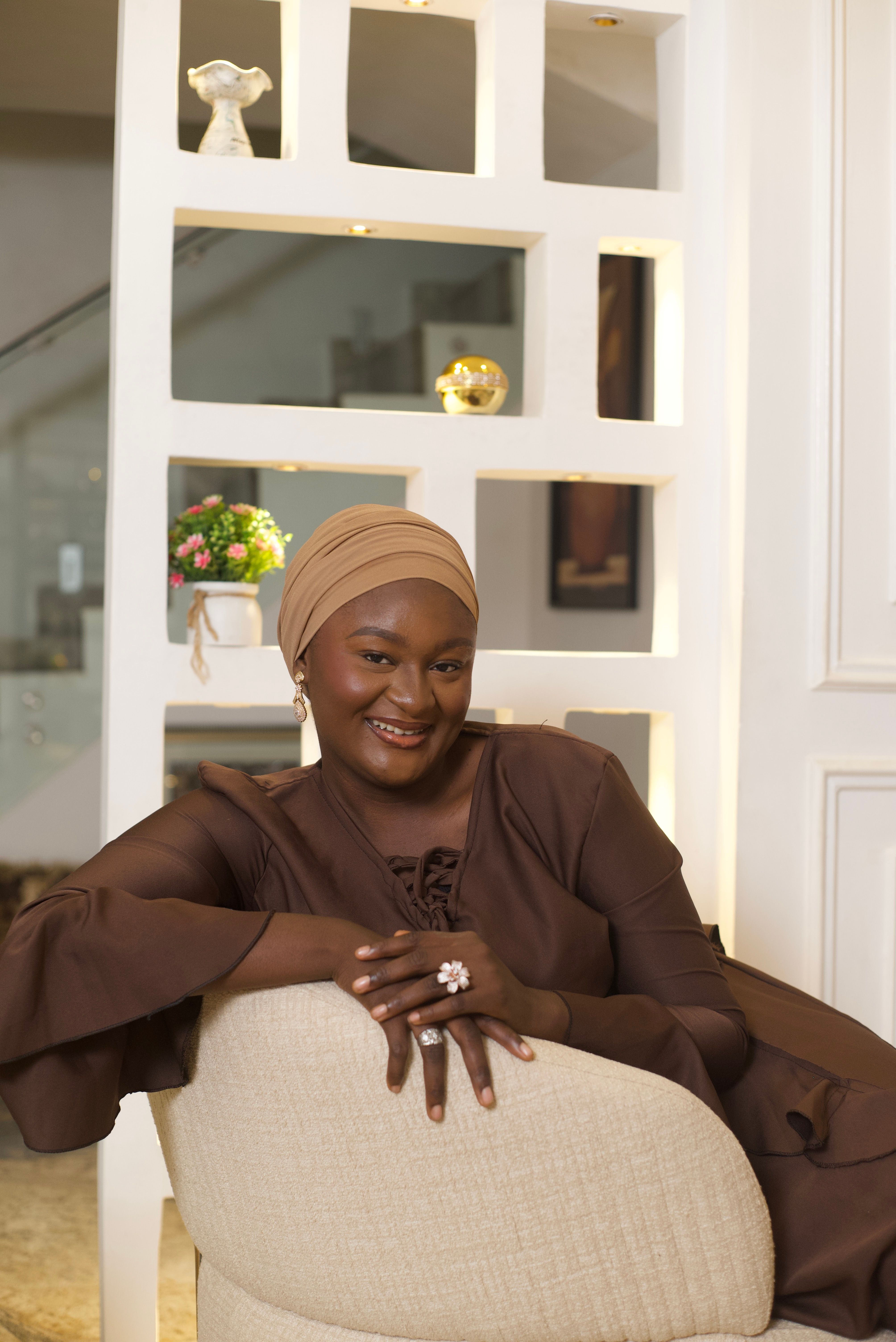 Stylish African woman smiling in a studio portrait with modern decor.
