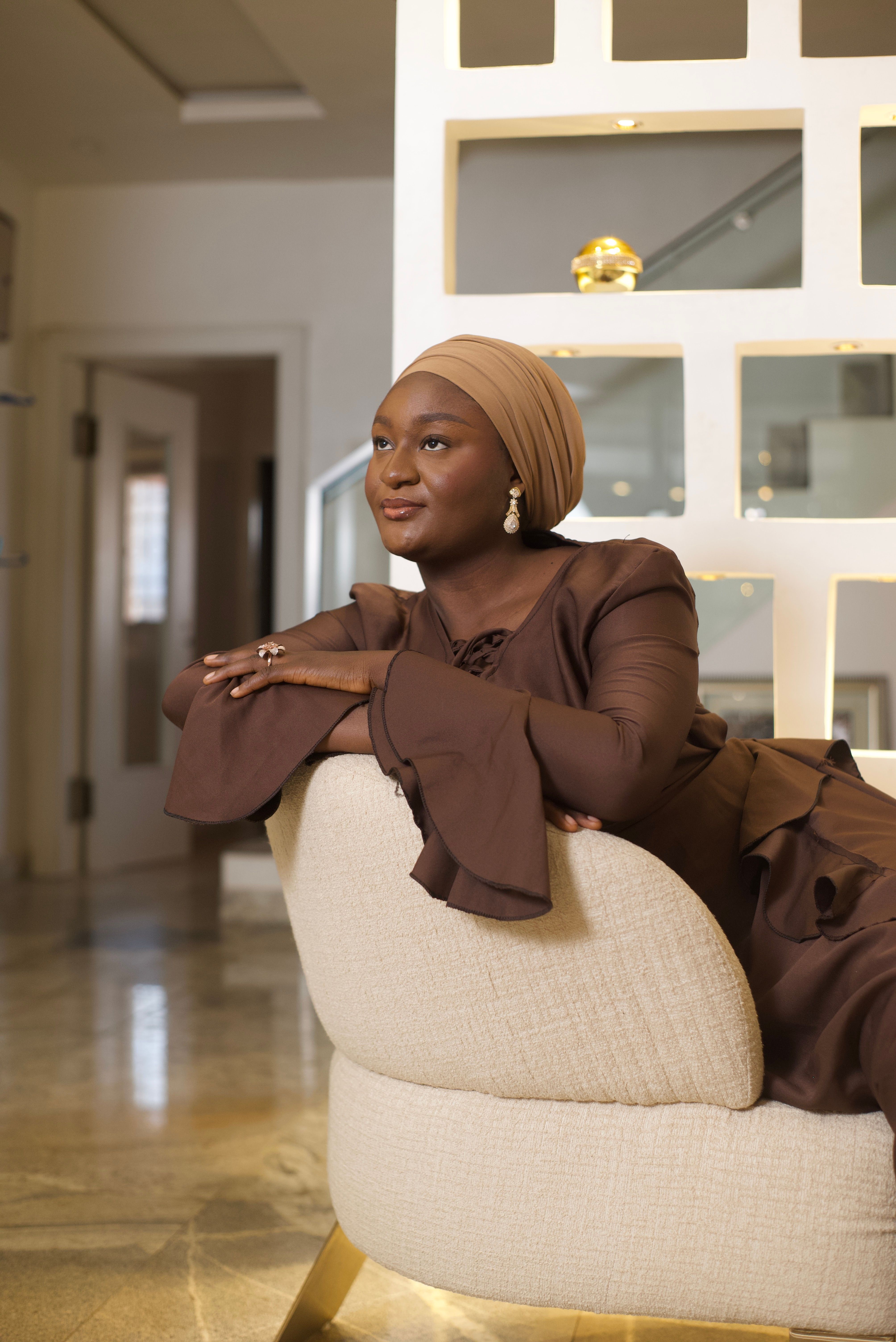 Chic studio portrait featuring a stylish African woman in a luxurious setting, showcasing elegant modest fashion.