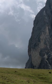 Majestic rock face under cloudy sky in the Dolomites, Italy.