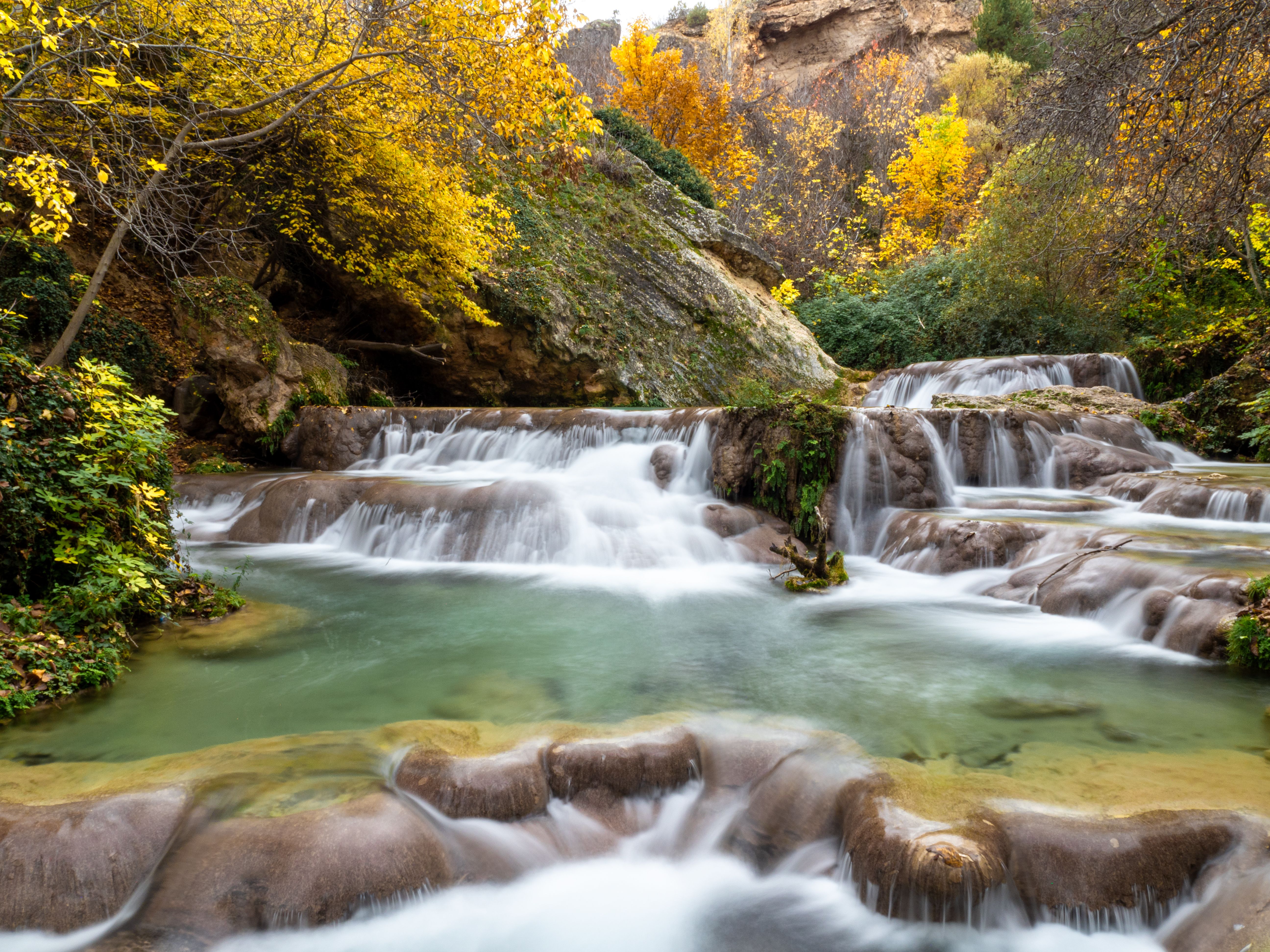 Serene Autumn Waterfall in Forest Landscape · Free Stock Photo