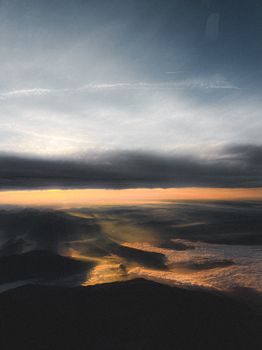 A breathtaking aerial shot of the Swiss Alps at sunset with sun rays streaming through clouds.
