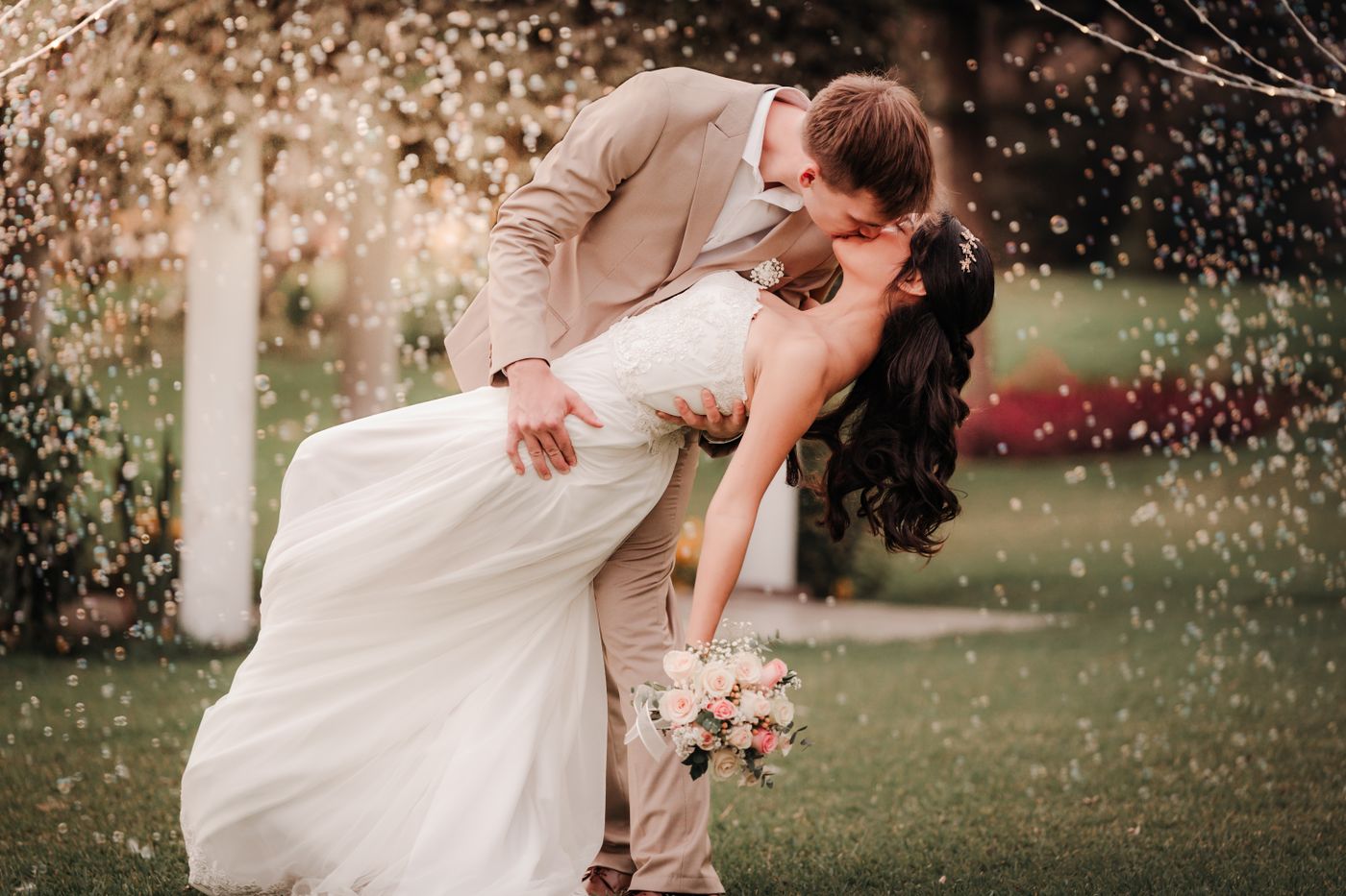 Wedding kiss beneath sparkling lights