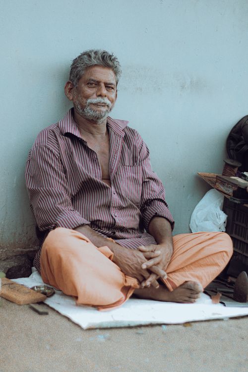 Free A thoughtful portrait of a senior Indian man sitting outside in Ernakulam, India. Stock Photo