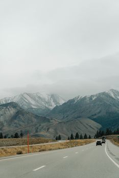 A serene road winding through snowy mountains on a winter day, perfect for adventurous travelers.