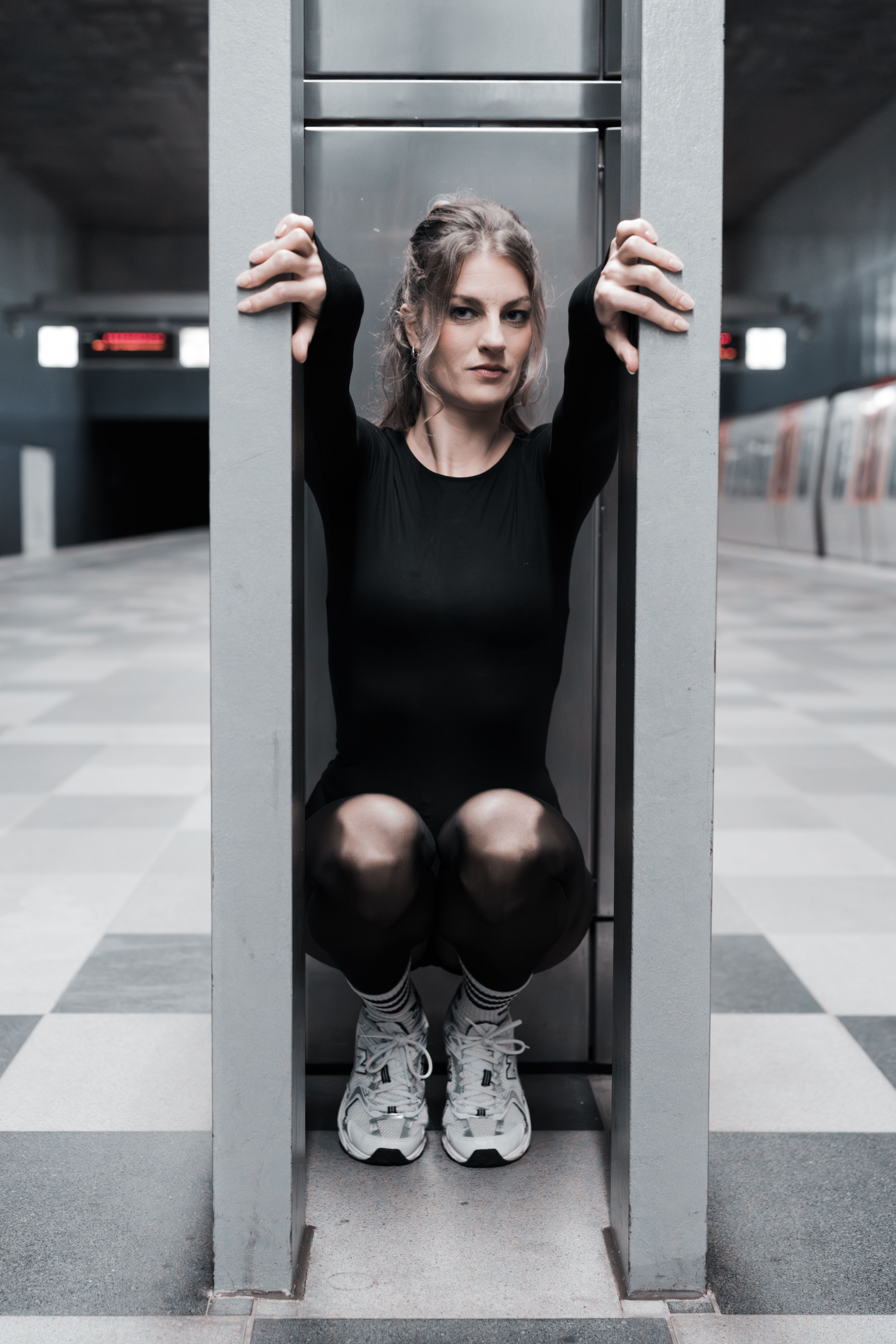 Elegant dancer posing in Hamburg's modern underground station, showcasing contemporary art in motion.