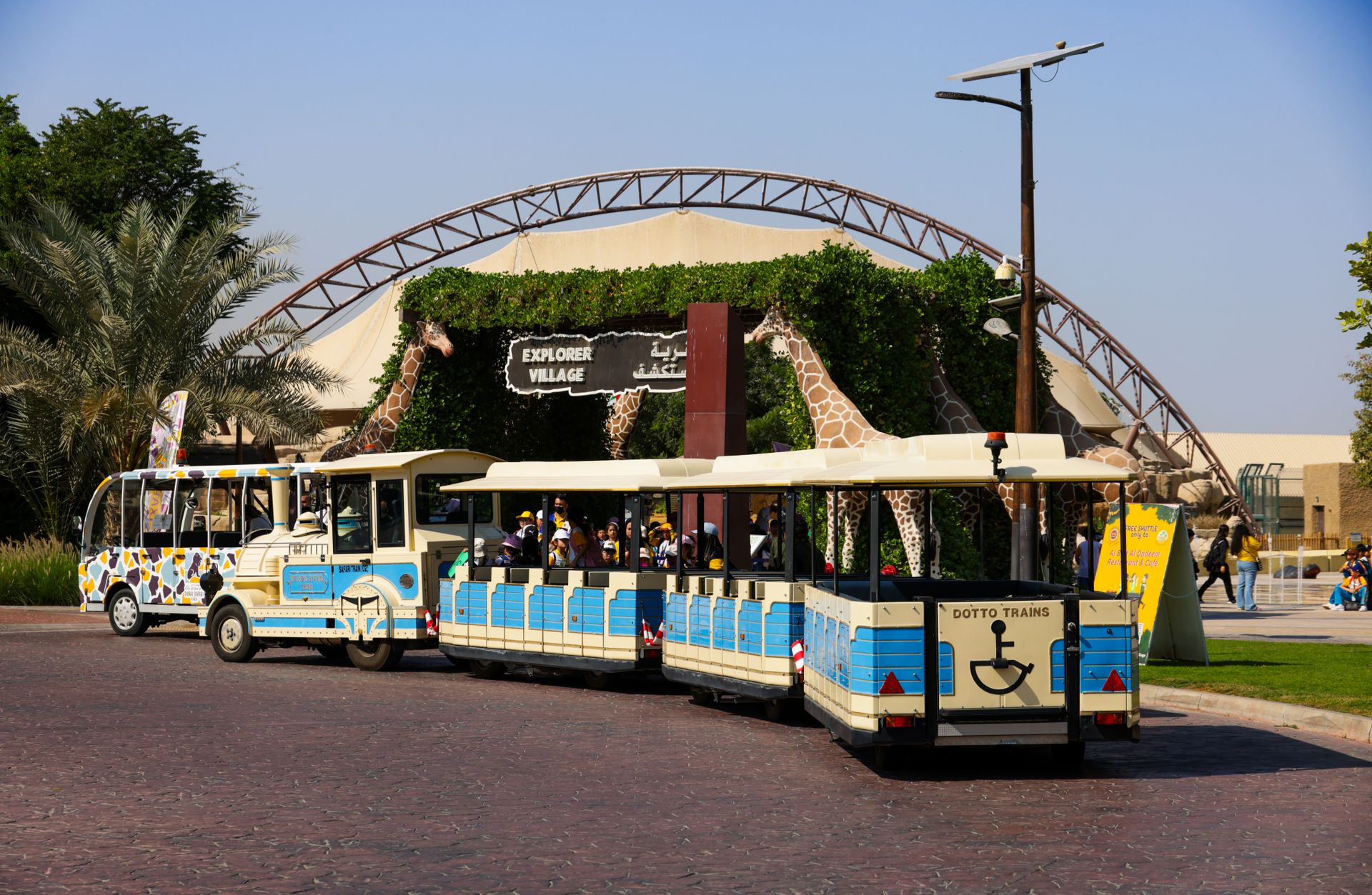 A vibrant scene of kids enjoying a mini train outside the Explorer Village.