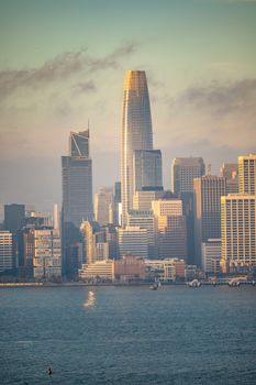 Stunning San Francisco skyline with Salesforce Tower during a serene sunset reflecting on the water.