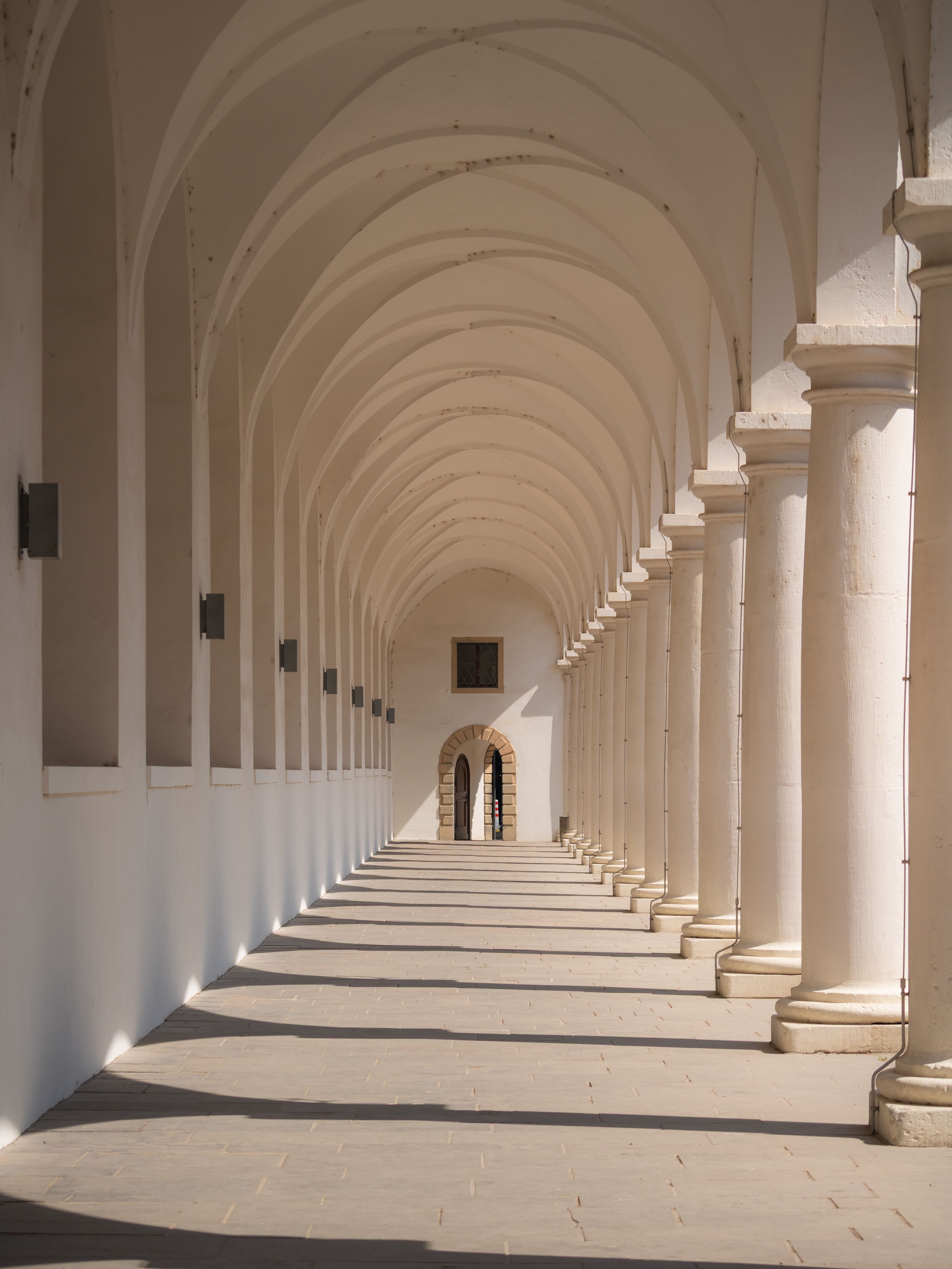 Sunlit arched corridor in Dresden with classic architectural design.