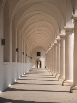 Sunlit arched corridor in Dresden with classic architectural design.