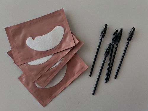 Free Flat lay of cosmetic eye pads and mascara wands on a neutral background, ideal for beauty themes. Stock Photo
