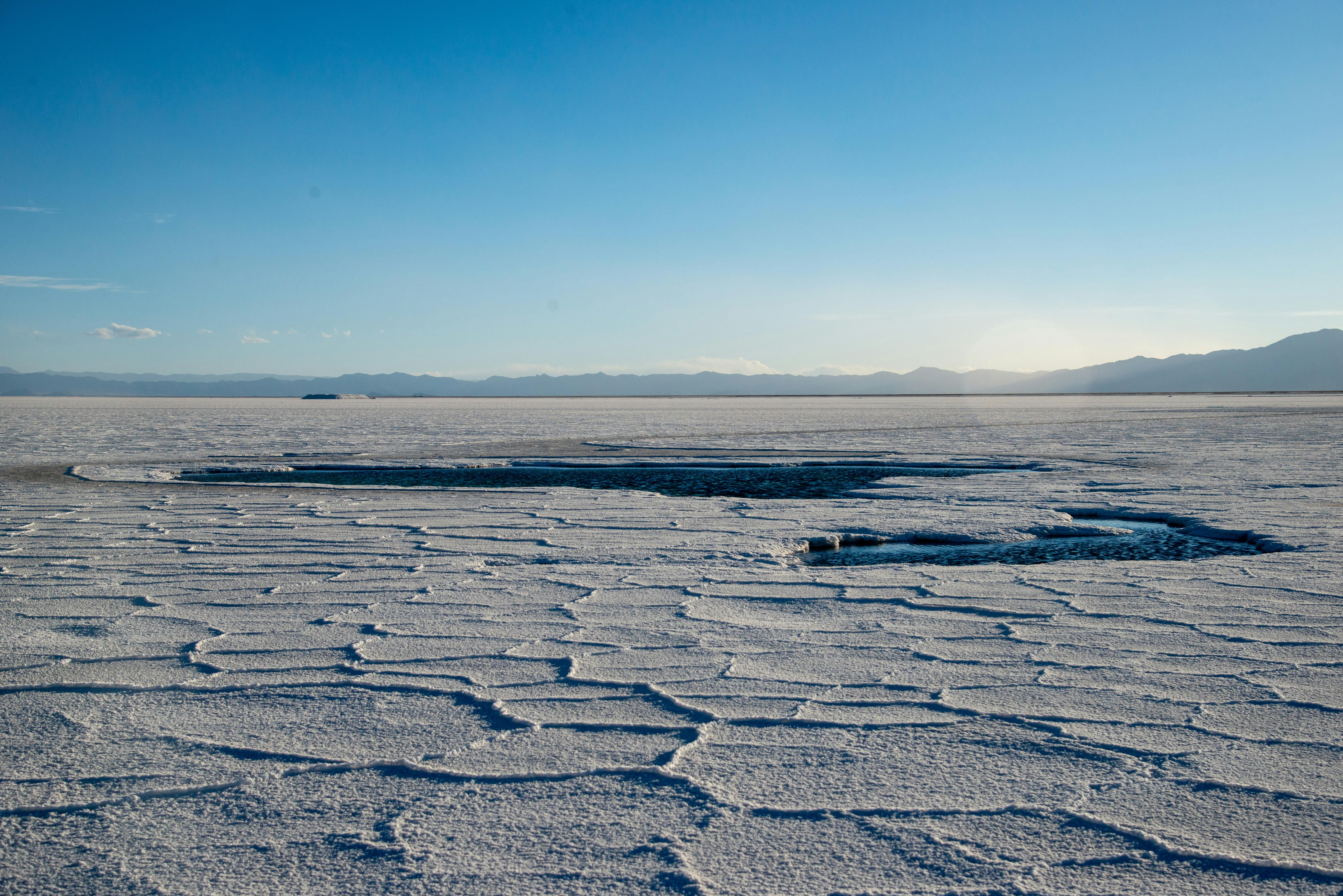 Scenic view of vast salt flats in Salta Province, Argentina under a clear blue sky.