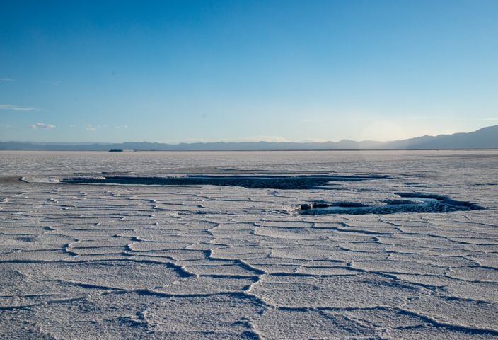 Scenic view of vast salt flats in Salta Province, Argentina under a clear blue sky.