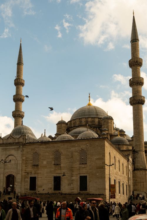 Free The Yeni Cami Mosque in Istanbul under a clear blue sky with pigeons flying by. Stock Photo