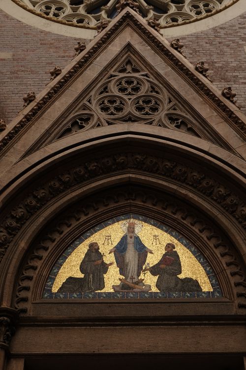 Free Ornate Gothic cathedral facade featuring a detailed religious mosaic above the entrance. Stock Photo