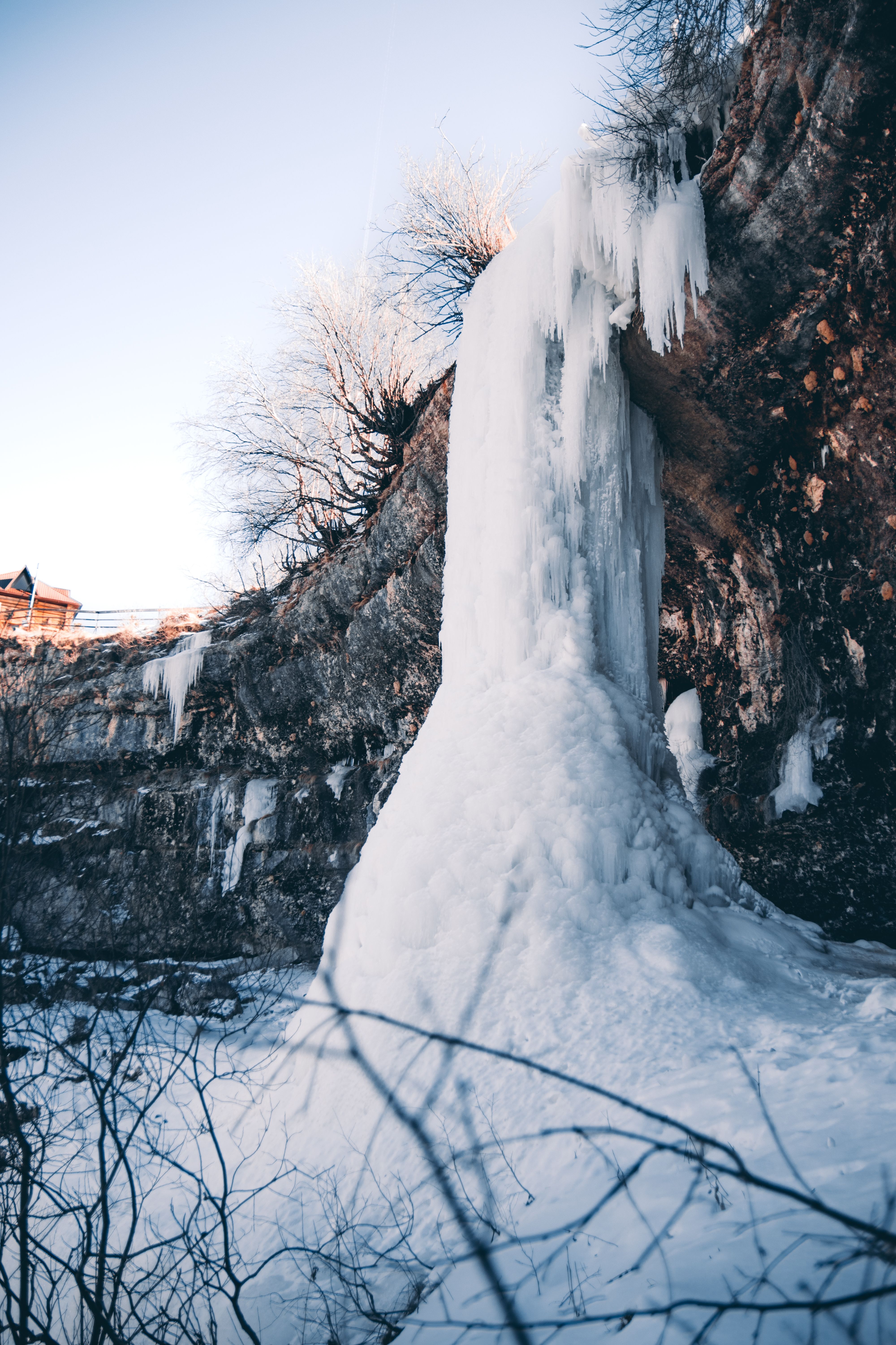 Stunning frozen waterfall amid snow-covered landscape, showcasing winter's beauty.
