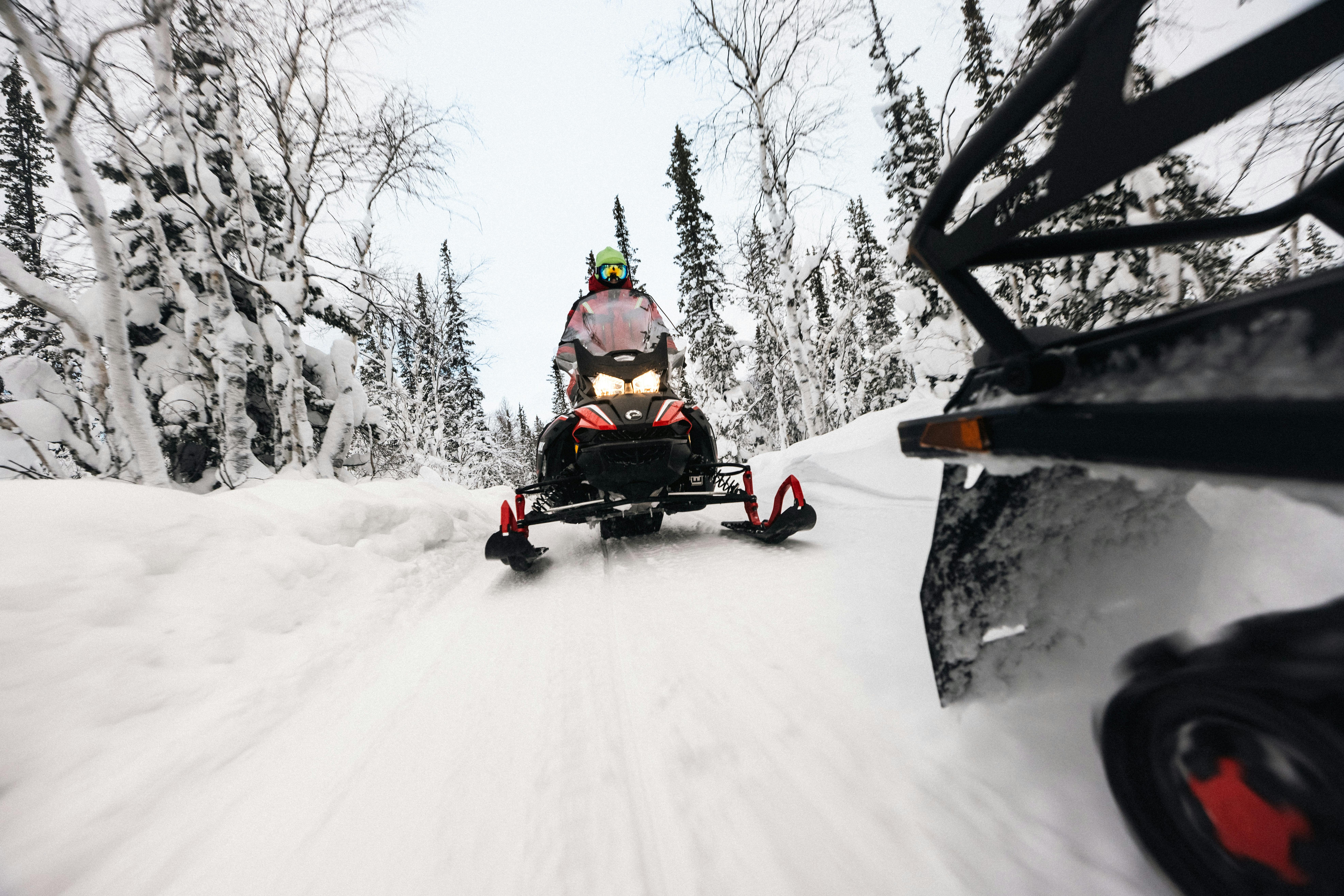 Dynamic snowmobile ride through a snowy forest, capturing the thrill and speed of winter adventure.
