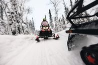 Dynamic snowmobile ride through a snowy forest, capturing the thrill and speed of winter adventure.