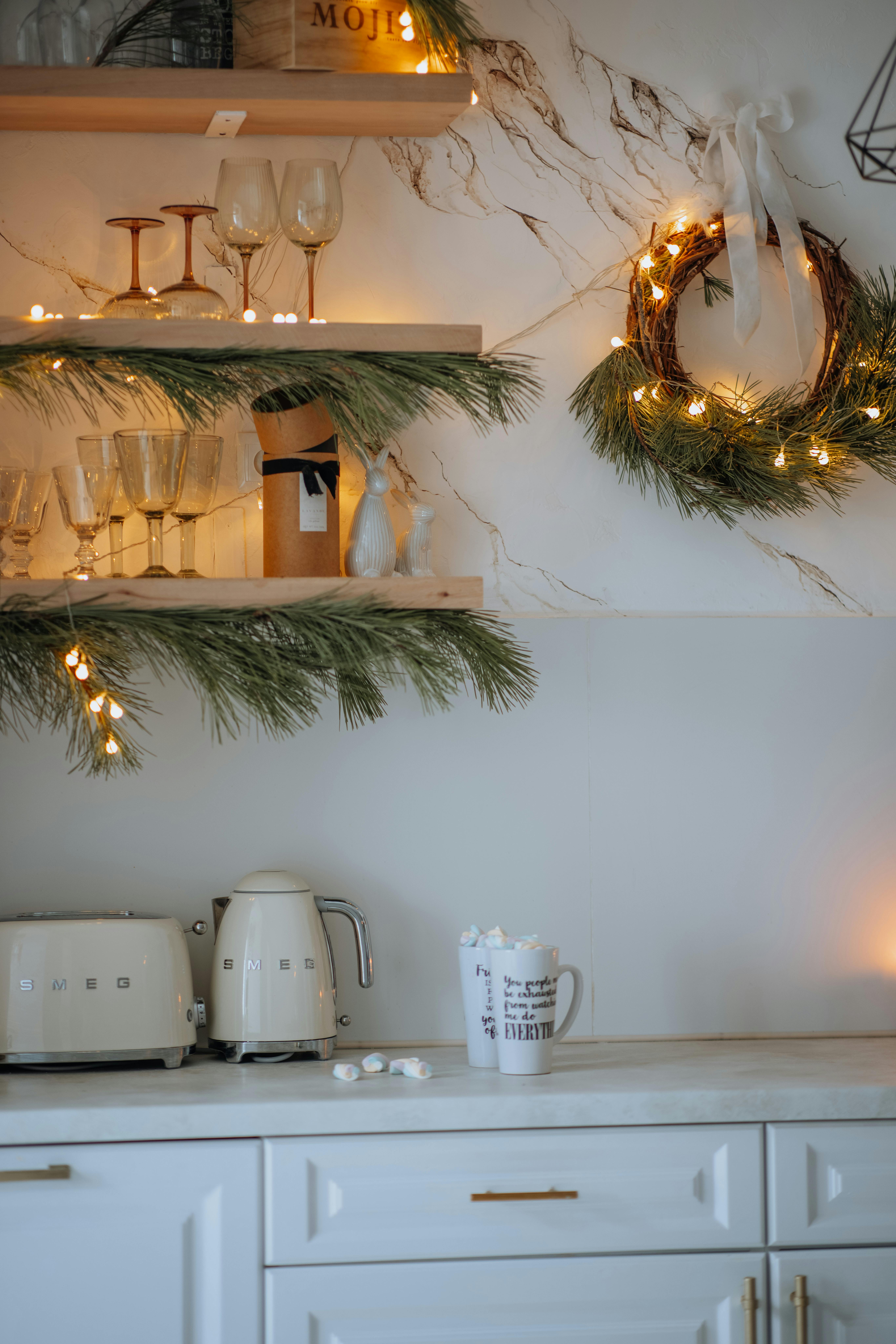 Modern kitchen with holiday decorations, lights, and stylish tableware, creating a warm festive atmosphere.