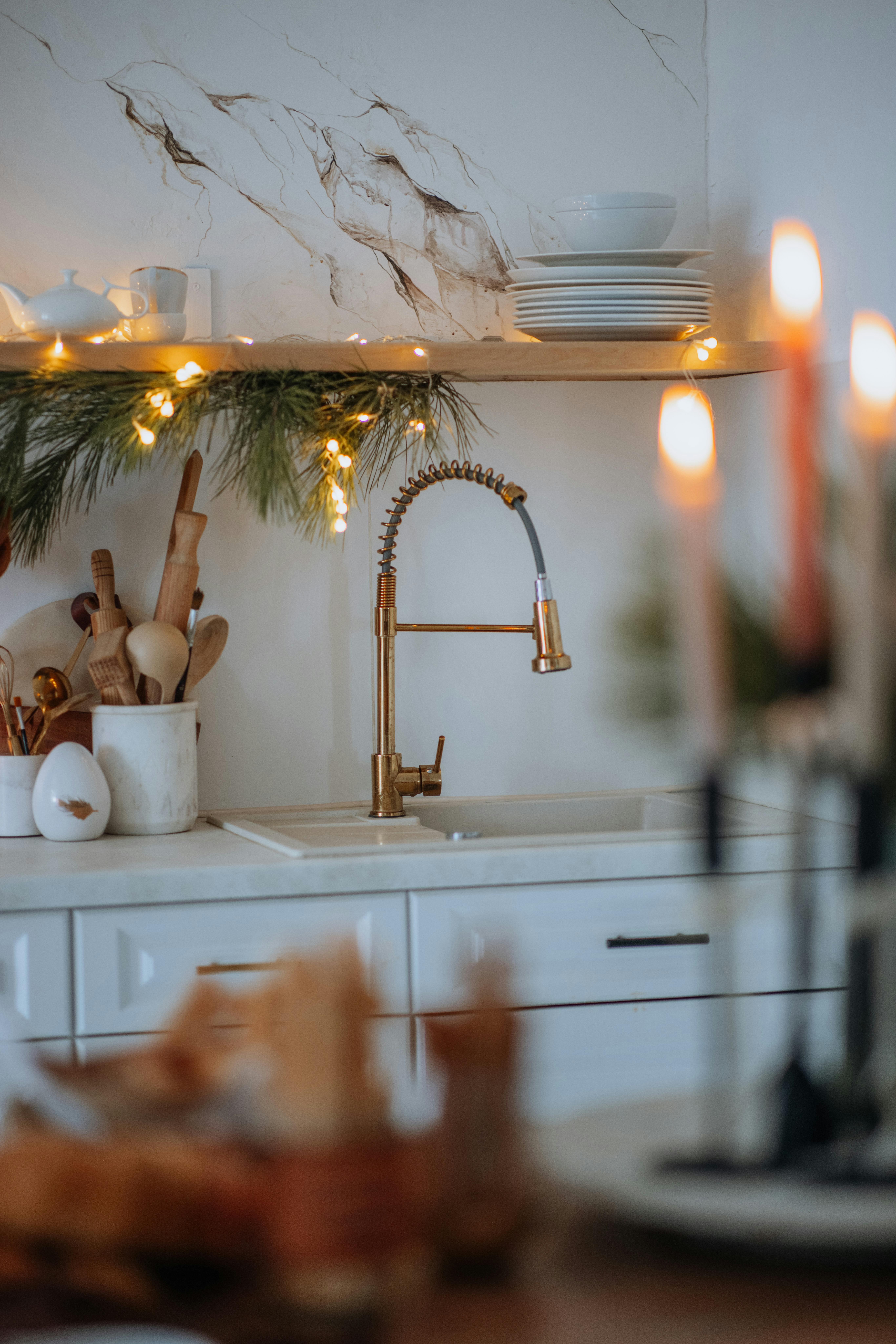 Warm kitchen setting with holiday decorations and elegant tableware.