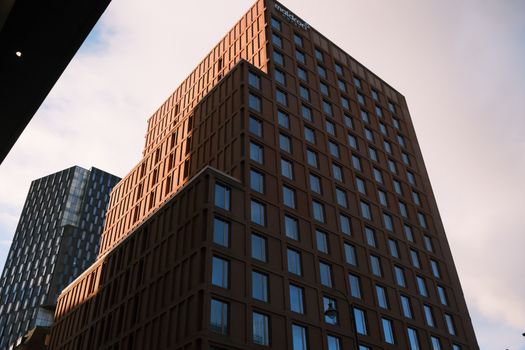 Dramatic view of modern city buildings with striking geometric designs at sunset.