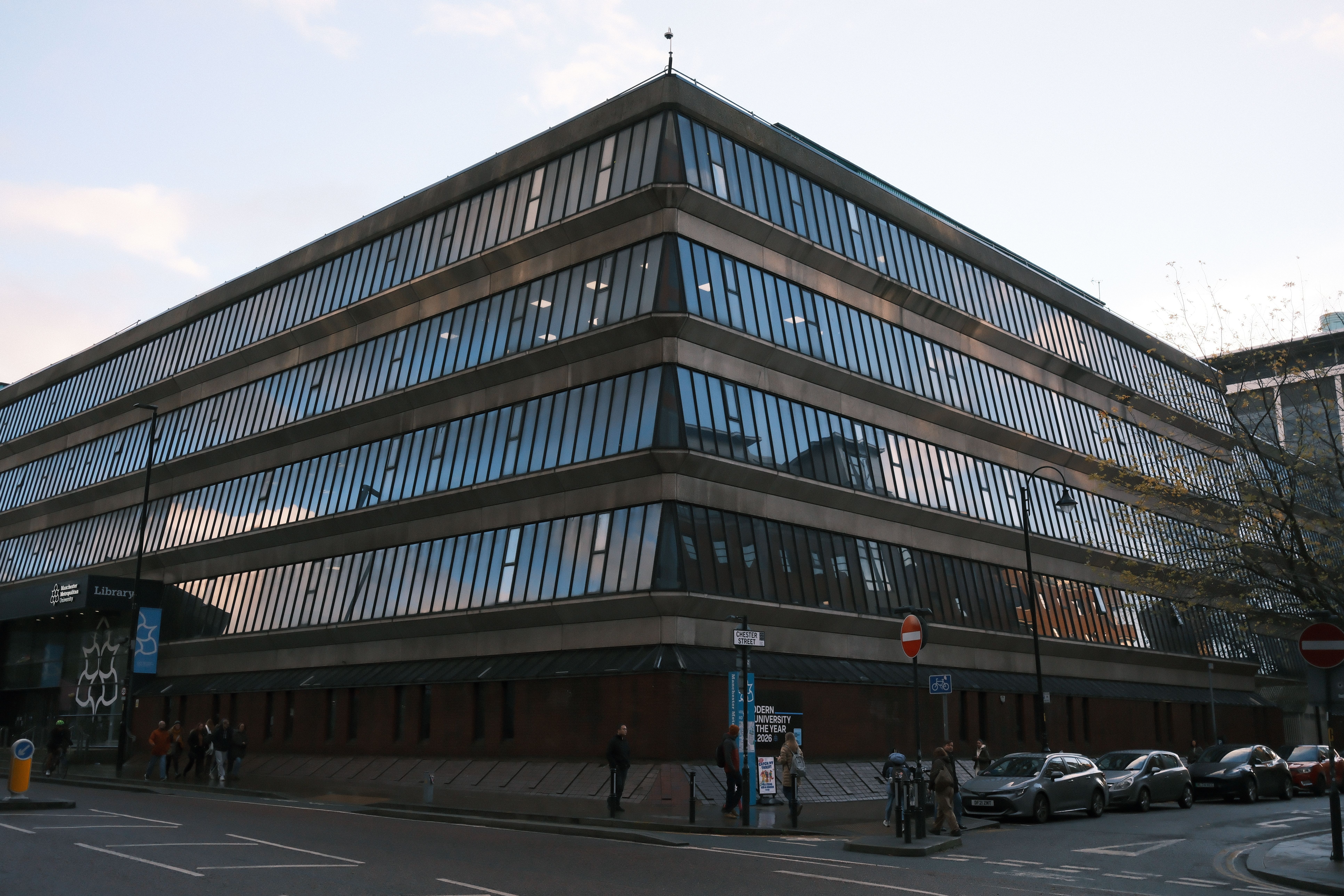 A striking modern library with sleek glass facade reflects the urban cityscape.