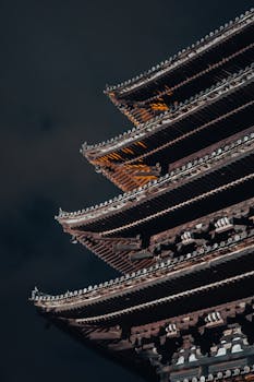 A stunning view of a traditional Japanese pagoda in Kyoto captured at night, showcasing intricate architecture.