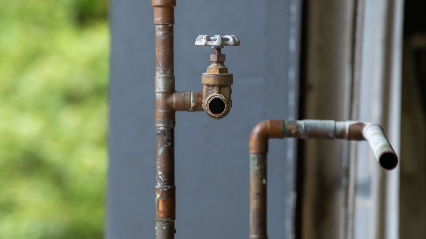 Old corroded plumbing pipes and valve on an aging home water line — free cast iron pipe inspection in Miami