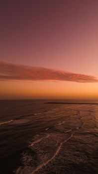 Stunning aerial view of a serene ocean with colorful sunset sky.
