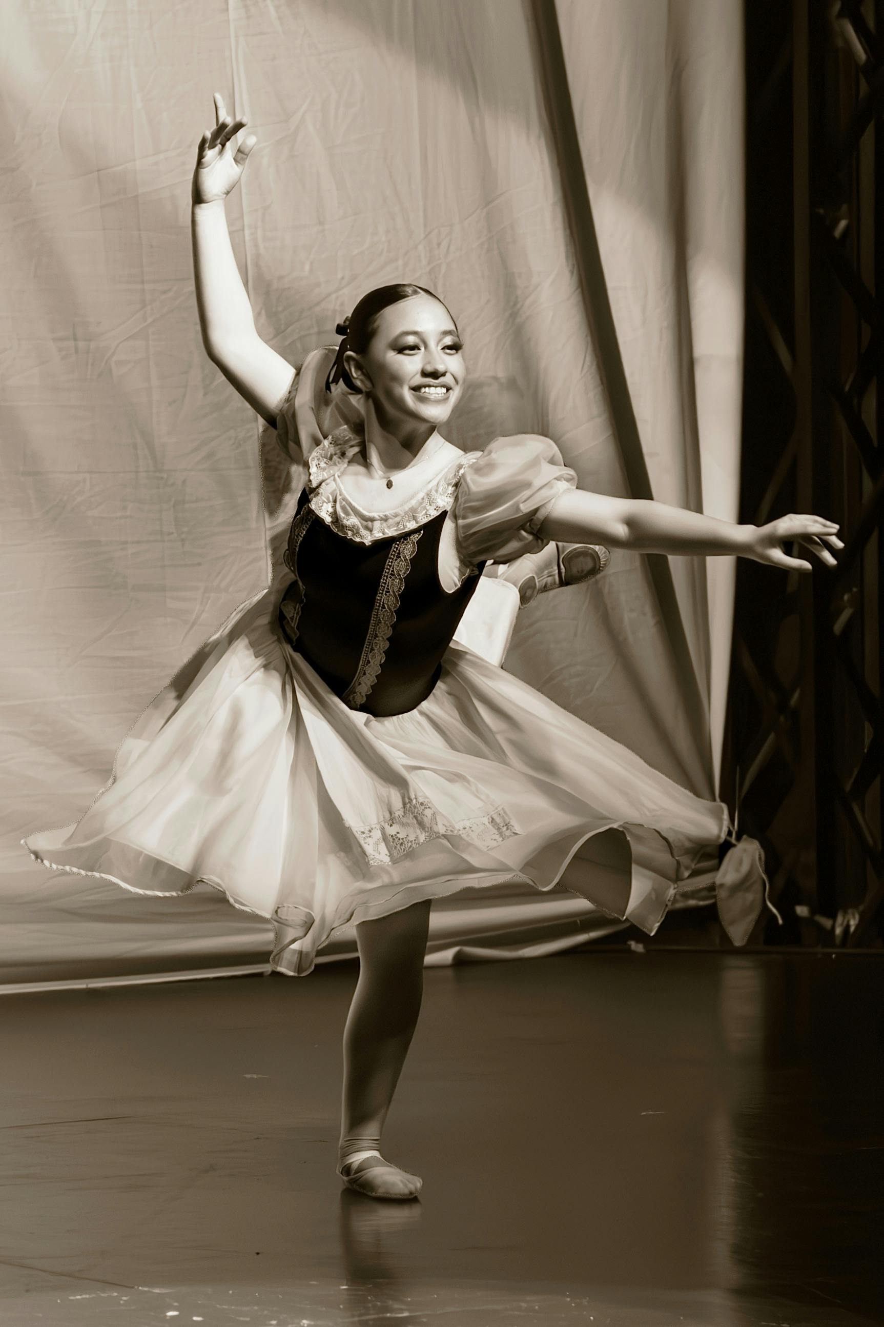 Ücretsiz Sahnede zarif bir performans sergileyen genç bale dansçısı, sepya tonlarında görüntülendi. Stok Fotoğraflar