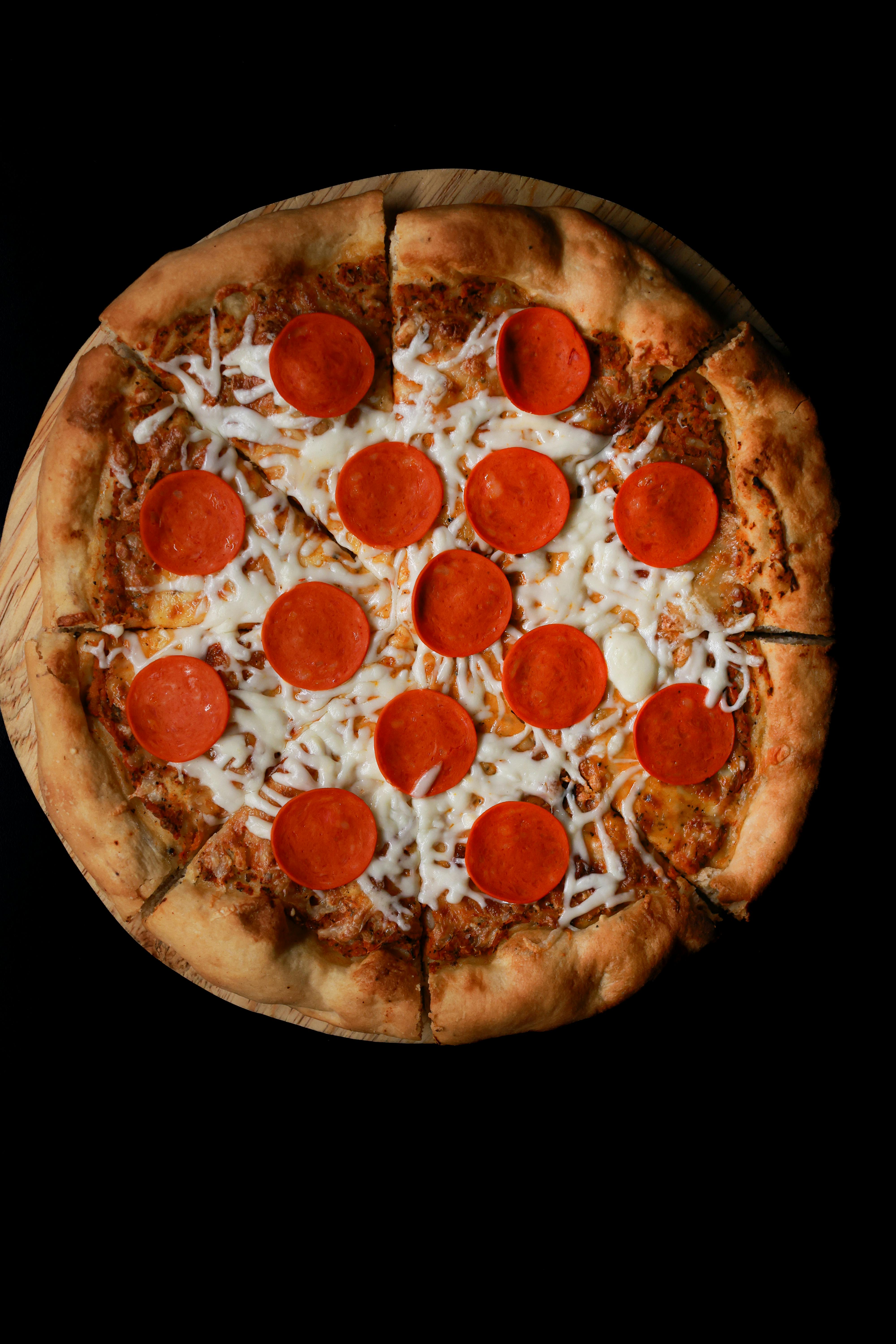 Appetizing pepperoni pizza with melted cheese on a wooden board.