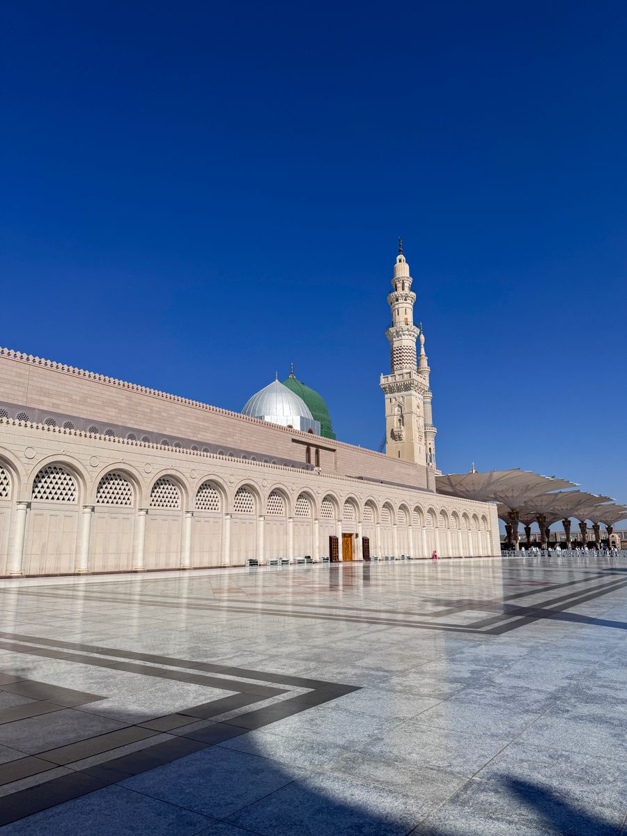Masjid Nabawi di Madinah dengan menara dan kubah di bawah langit biru untuk pakej Umrah Ekonomi Madinah