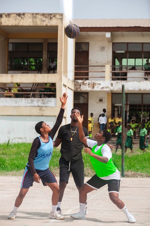 Free Two teenagers playing basketball with a coach in an outdoor basketball court during the day. Stock Photo
