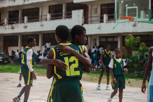 Free High school basketball players celebrating after scoring. Emphasis on team spirit and youth sports. Stock Photo