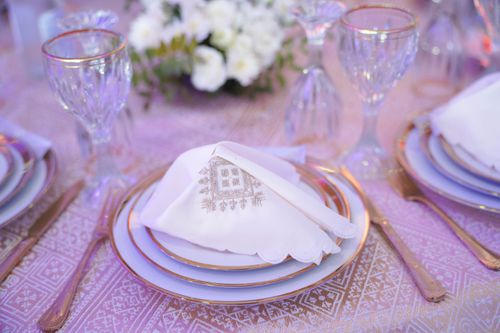 Free Luxurious table setting with gold rimmed glassware and ornate napkin design. Stock Photo