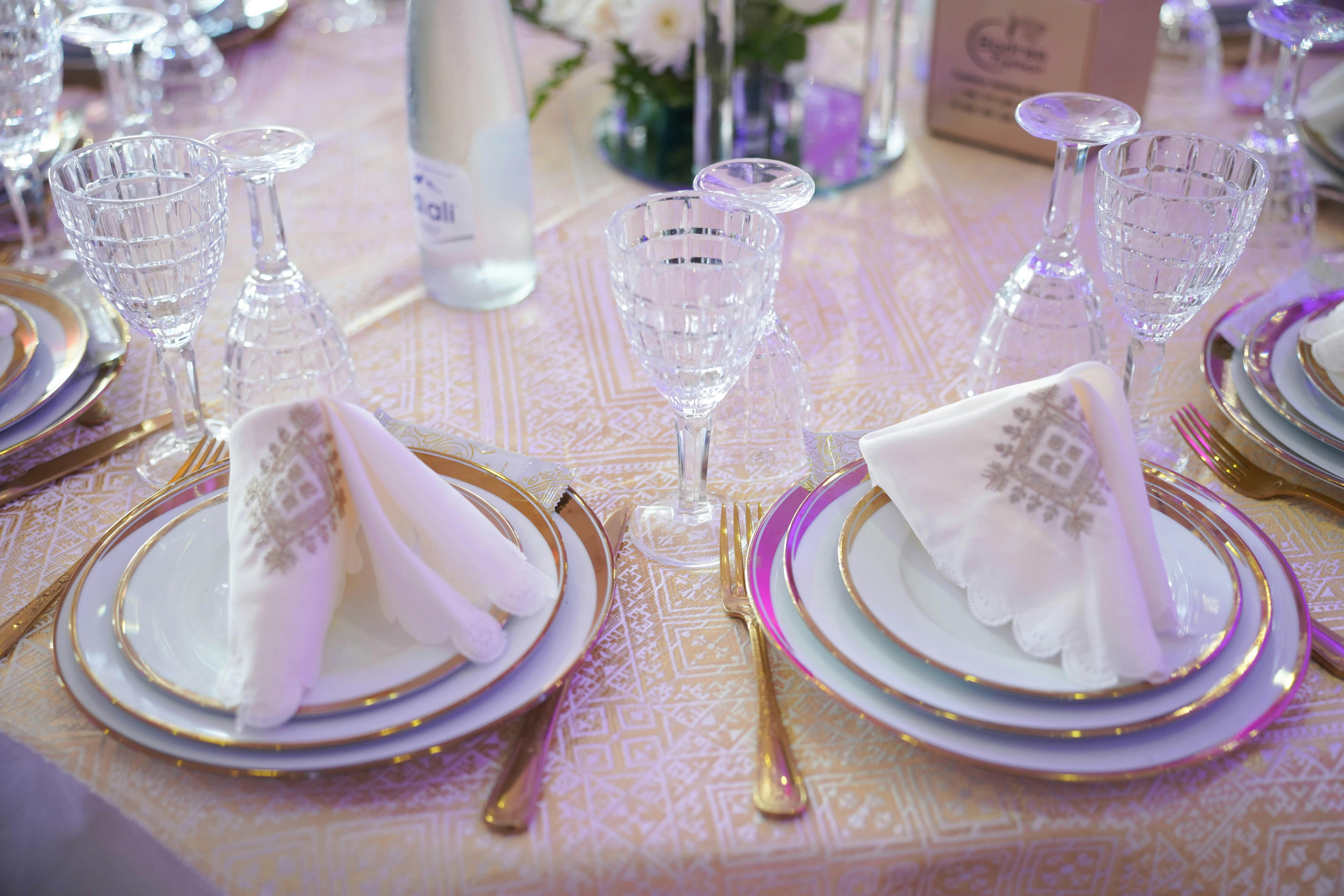Beautifully arranged formal table setting with crystal glassware and ornate napkins, ideal for weddings or special occasions.