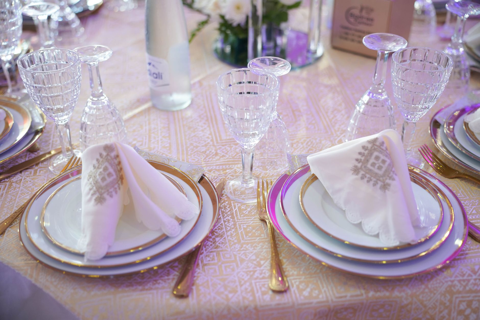 Beautifully arranged formal table setting with crystal glassware and ornate napkins, ideal for weddings or special occasions.