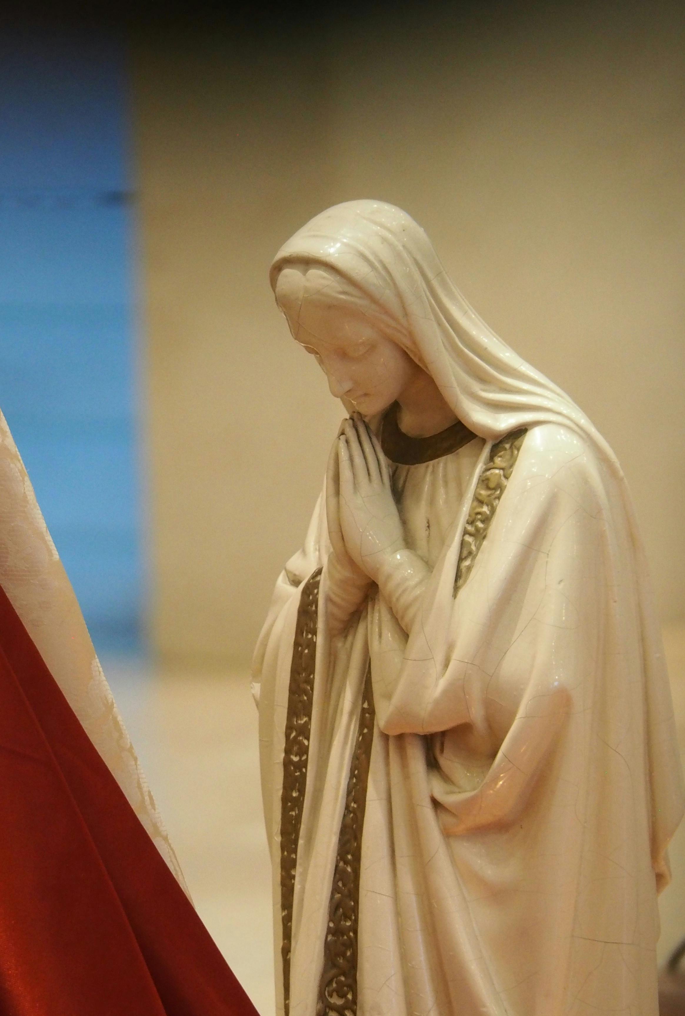 A serene statue of the Virgin Mary in prayer reflecting peace and devotion.