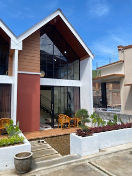 Contemporary townhouse featuring large windows, wooden accents, and a small front garden.
