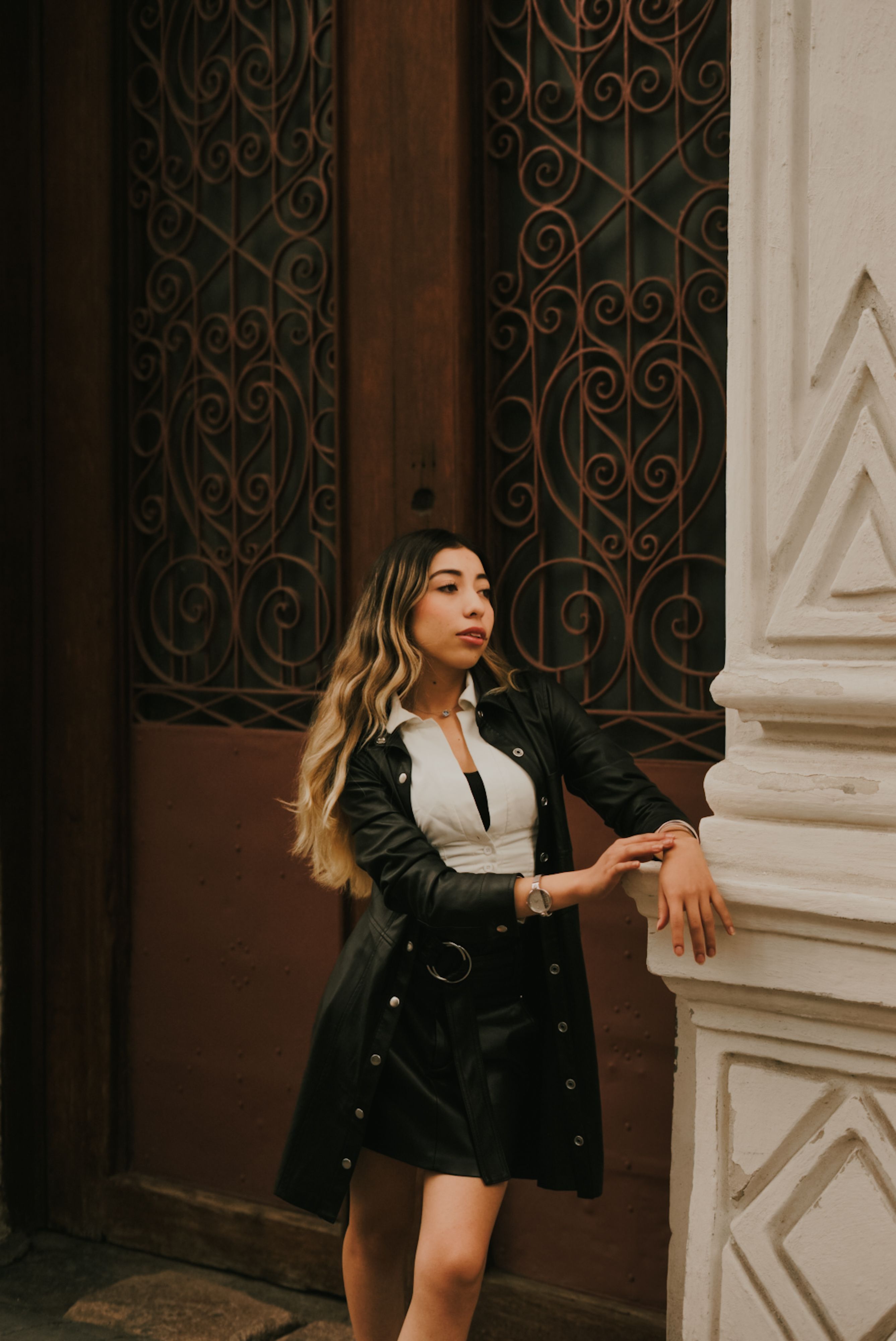 Smiling Young Model in a Leather Jacket and Black Mini Dress Posing on the  Sidewalk  Free Stock Photo