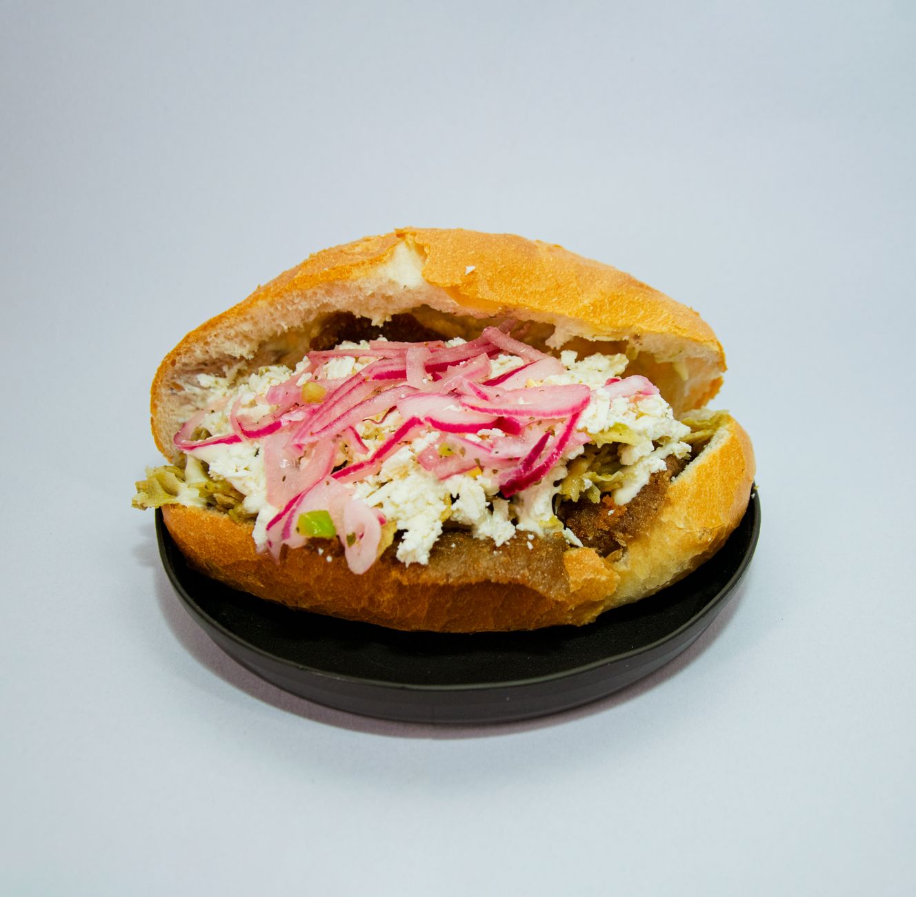 Mexican torta sandwich cut in half showing layers of fillings and bread texture
