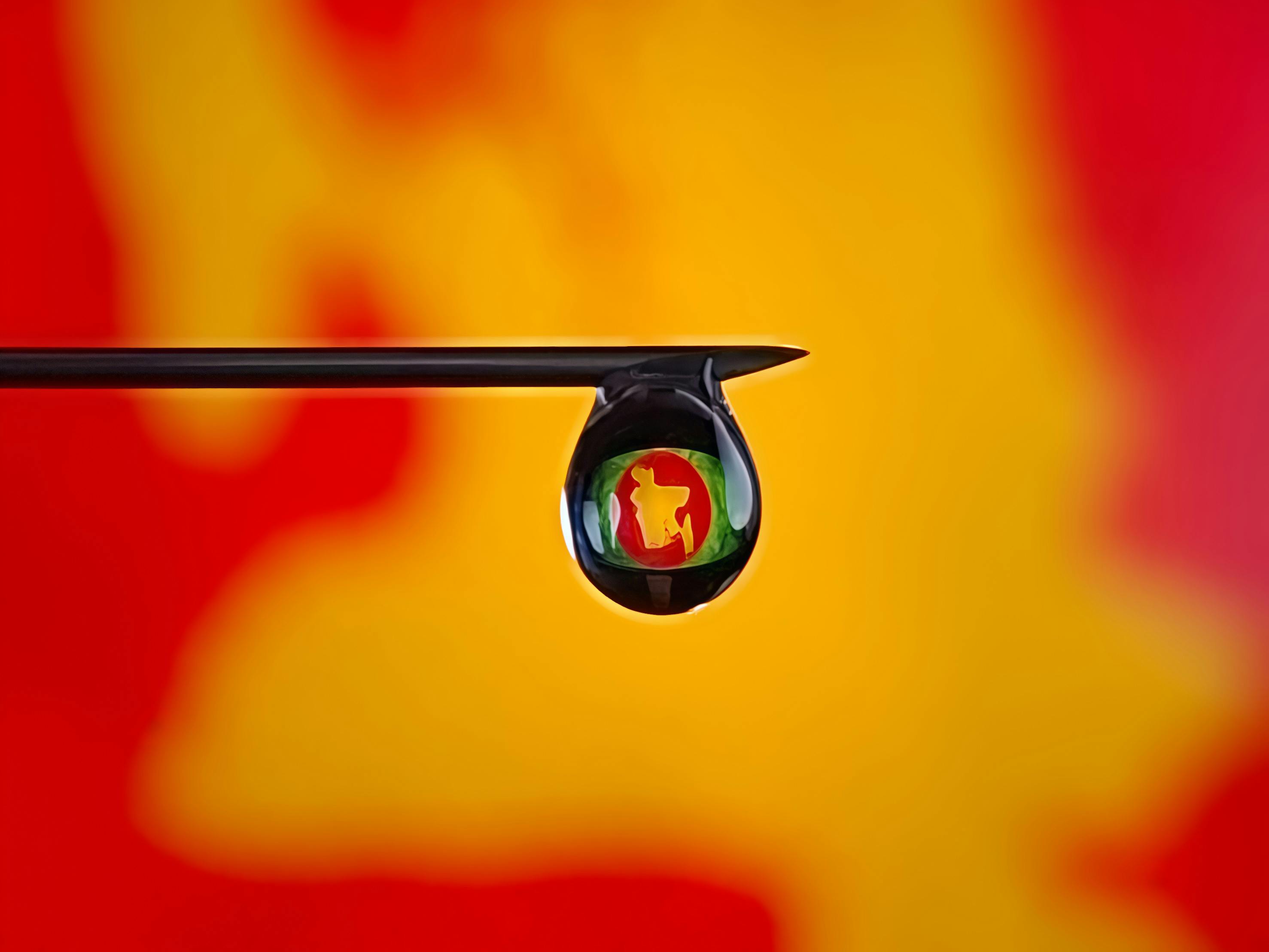 gratis Abstracte macrofotografie met een kleurrijke weerspiegeling in een waterdruppel op een naald. Stockfoto