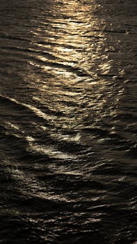 Capture of shimmering golden light on Ganges River's surface at sunrise in Varanasi.