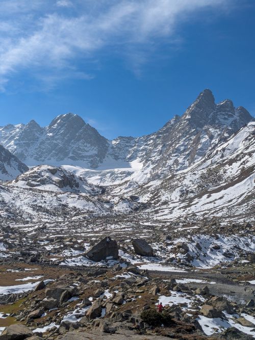 Free Breathtaking snowy mountain landscape with a lone hiker hiking during winter. Stock Photo