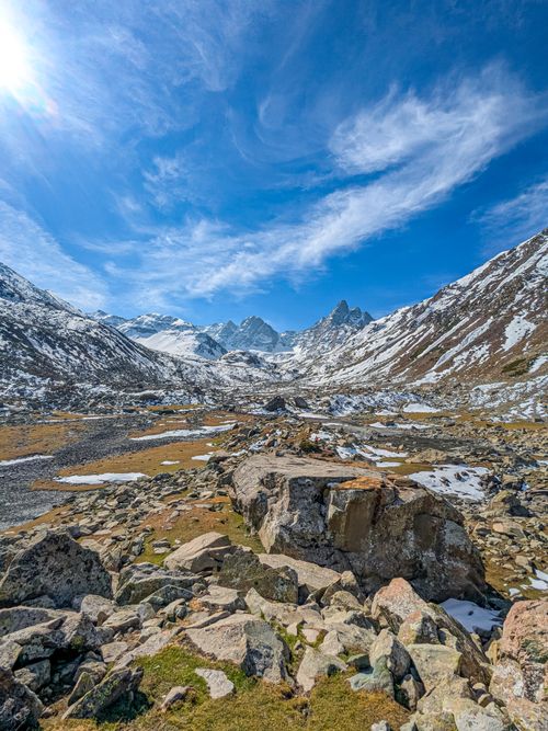 Free Breathtaking view of snow-capped mountains and rocky terrain under a bright blue sky. Stock Photo