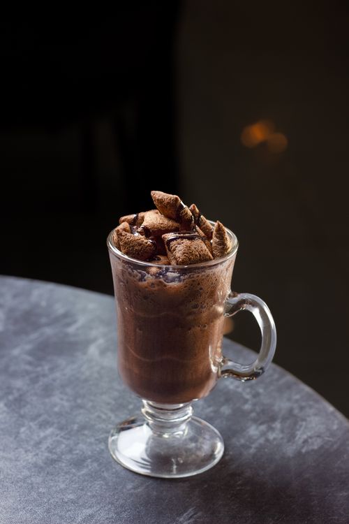 Free A tempting hot chocolate drink topped with cookies in a cozy cafe setting. Stock Photo